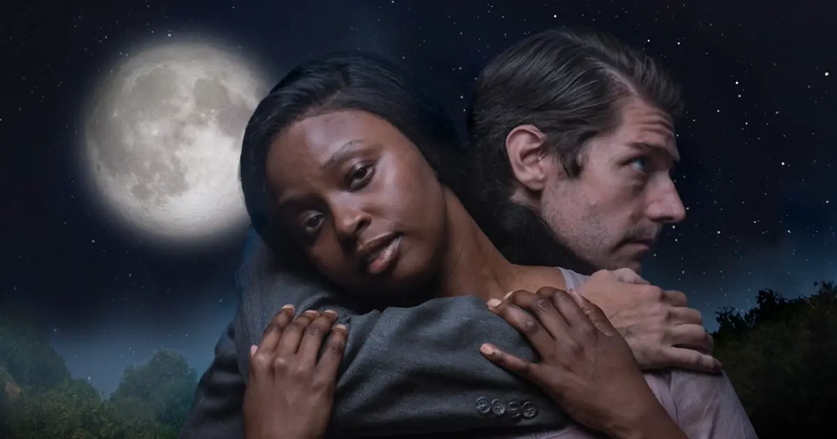 Actors embracing under full moon